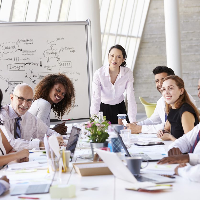 Asian Businesswoman Leading Meeting At Boardroom Table